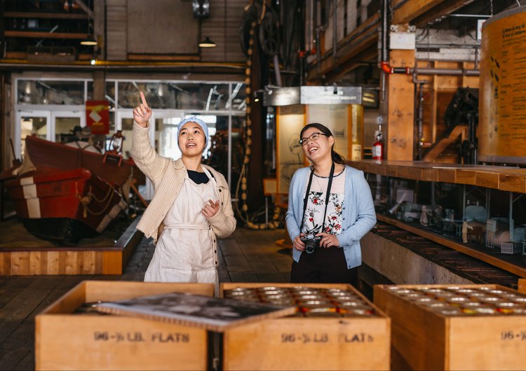 Girl gives someone a guided tour of the Gulf of Georgia Cannery National Historic Site